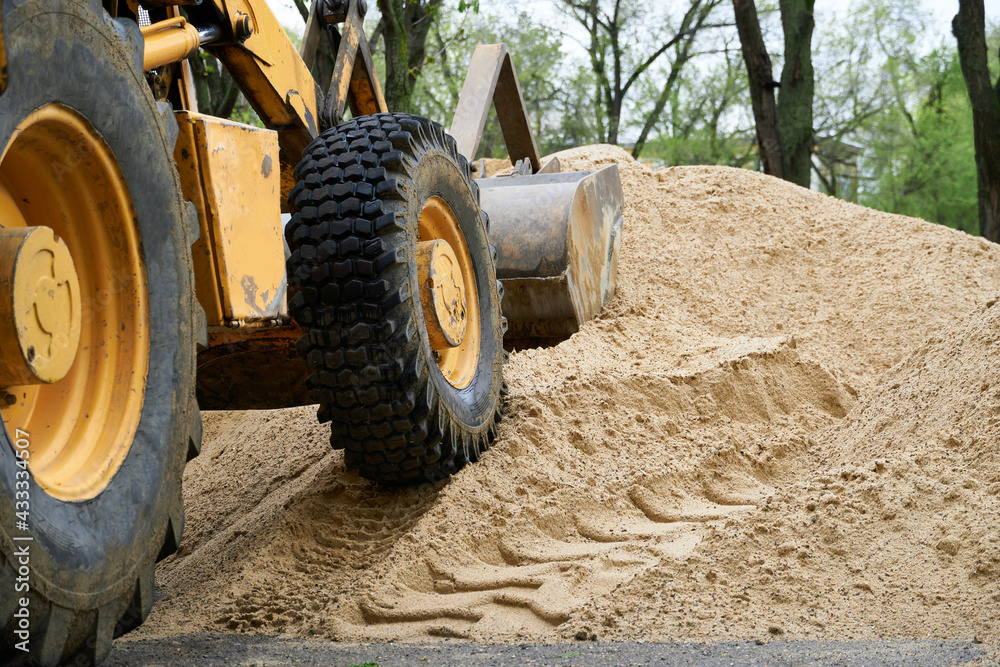 tractor or bulldozer works with a pile of sand for construction tractor or bulldozer works with a pile of sand for construction