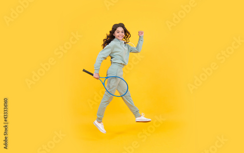 happy energetic teen girl jump in sportswear with badminton racket running to success, hurry up.
