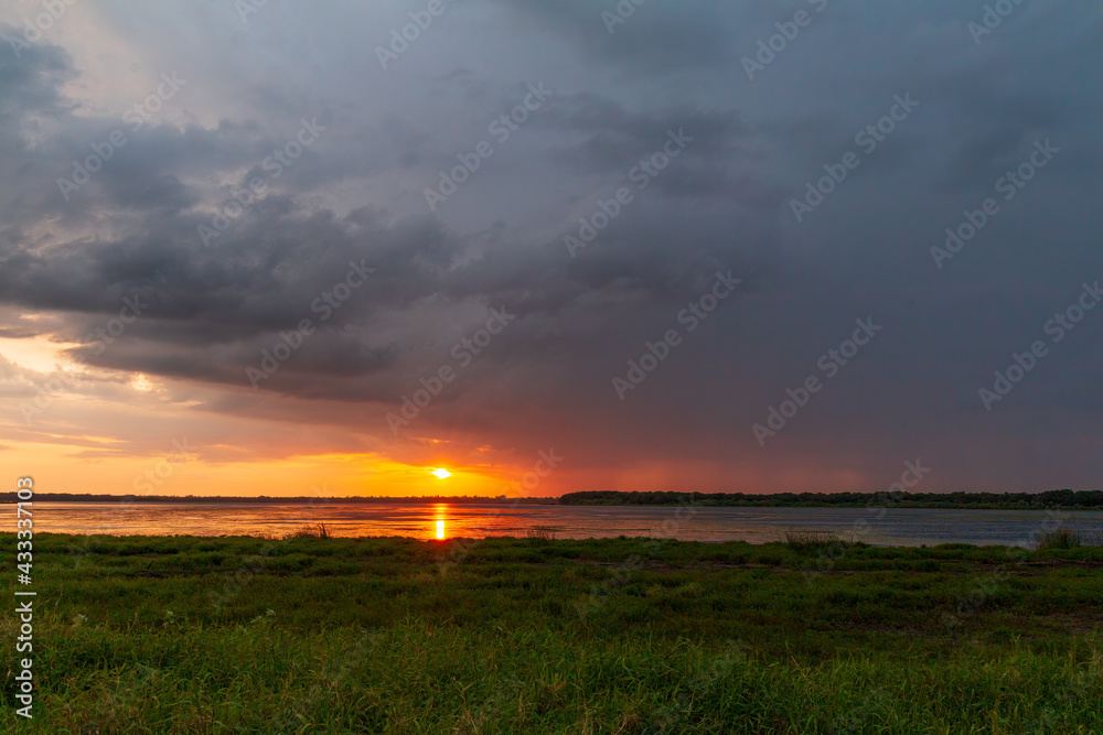 Stormy Sunset over Myakka River State Park with Beautiful Storm Clouds and Rain Falling In distance Stormy Sunset over Myakka River State Park with Beautiful Storm Clouds and Rain Falling In distance