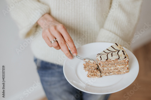 person breaks off a piece of cake