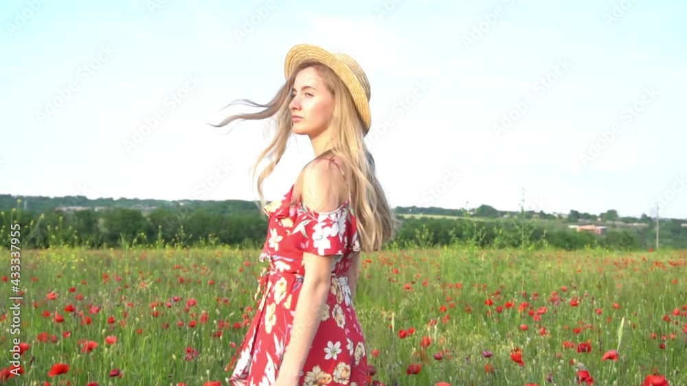 Slow Motion Beautiful young girl in a dress and hat walks in a field of flowerin Slow Motion Beautiful young girl in a dress and hat walks in a field of flowerin