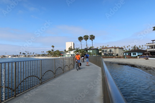Man Riding on a Bridge Next to a Bay on a Bike Trail in Mission Bay, San Diego, California