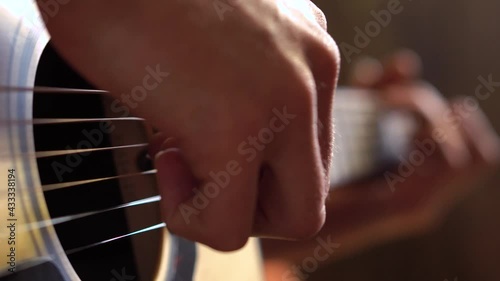 Playing the guitar. Closeup of man's hand strumming on solid spruce acoustic guitar