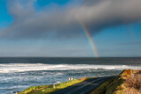 Colorful rainbow over Atlantic ocean, Mullaghmore, county Sligo, Ireland. Blue cloudy sky. Small road by the ocean