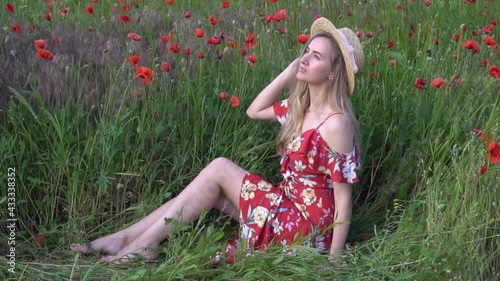 Slow Motion Young girl in hat posing in the poppy field. photo