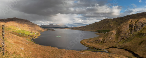 Panorama image of Lough Fee in Connemara, county Galway, Ireland. Beautiful lake surrounded by mountains, Cloudy sky. Calm and ethereal atmosphere