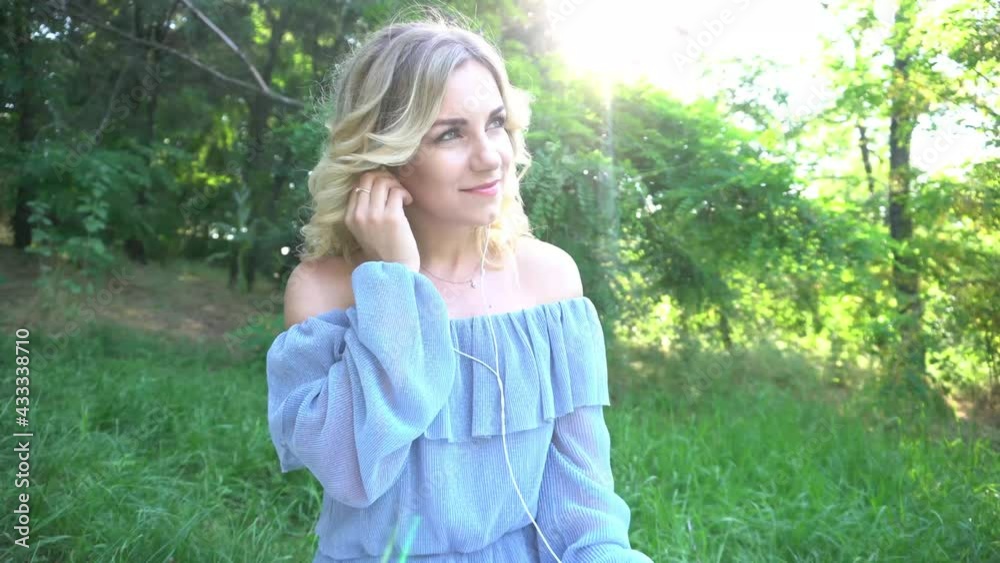 4K Girl in straw hat and dress sitting on blanket and takes off earphones, relax 4K Girl in straw hat and dress sitting on blanket and takes off earphones, relax
