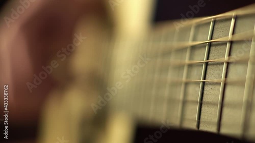 Closeup of guitar neck. Playing the guitar. Strumming on solid spruce acoustic guitar. Slow motion
