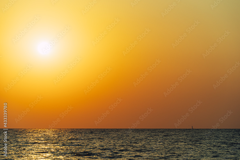 Scenic view of Sun in orange sky reflecting on the water during sunset