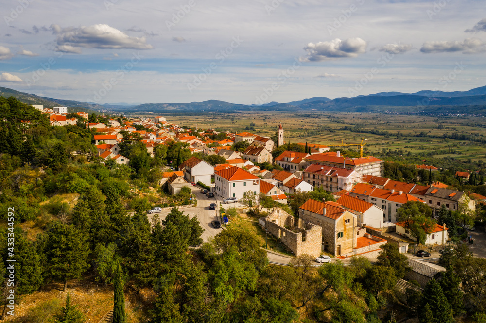 Aerial view of Imotski, a small town in the Dalmatian hinterland with medieval Topana fortress and blue sky. Nature summer landscape, outdoor travel background, Dalmatia, Croatia. August 2020