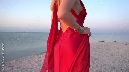 Slow Motion Young woman on a beach with red fabric photo