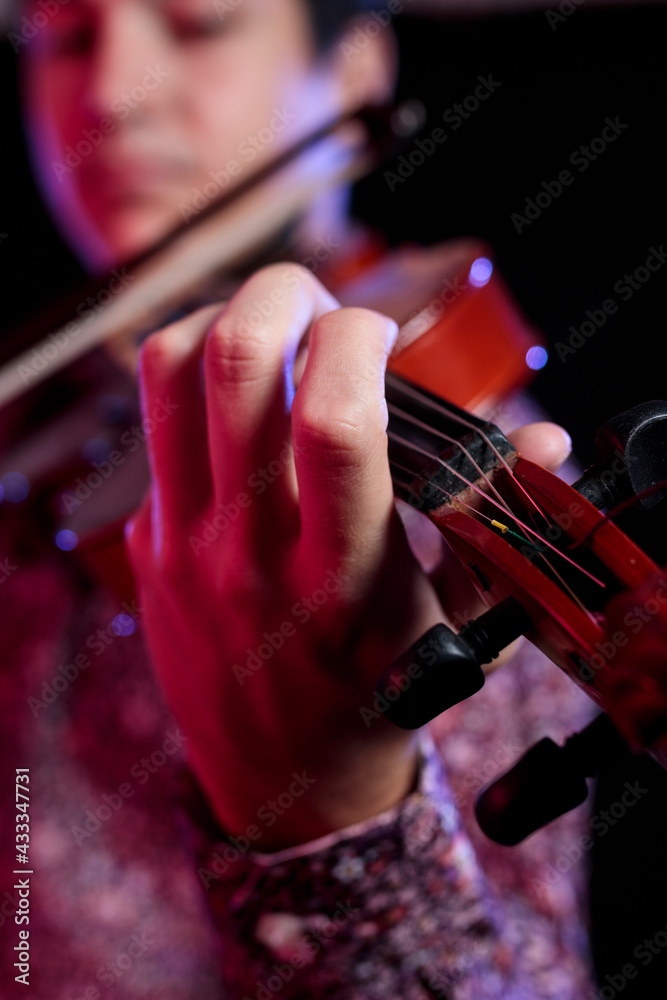 Young Caucasian musician playing violin. Classical music instrument. String equipment. Selective focus on hand. Art and music portrait on white background.