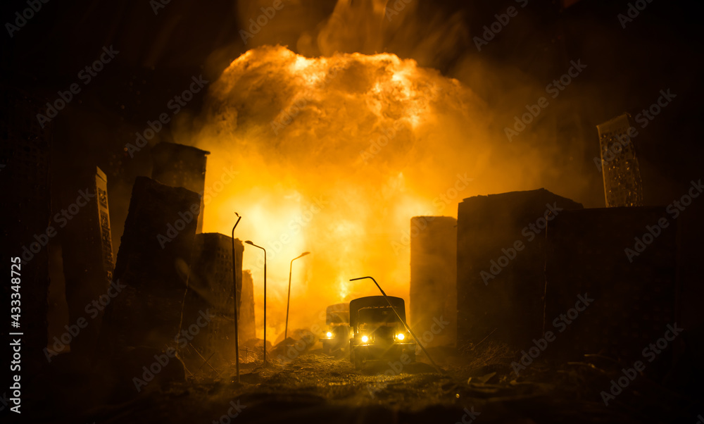 Empty street of burnt up city, flames on the ground and blasts with smoke in the distance. Apocalyptic view of city downtown as disaster film poster concept. Night scene.