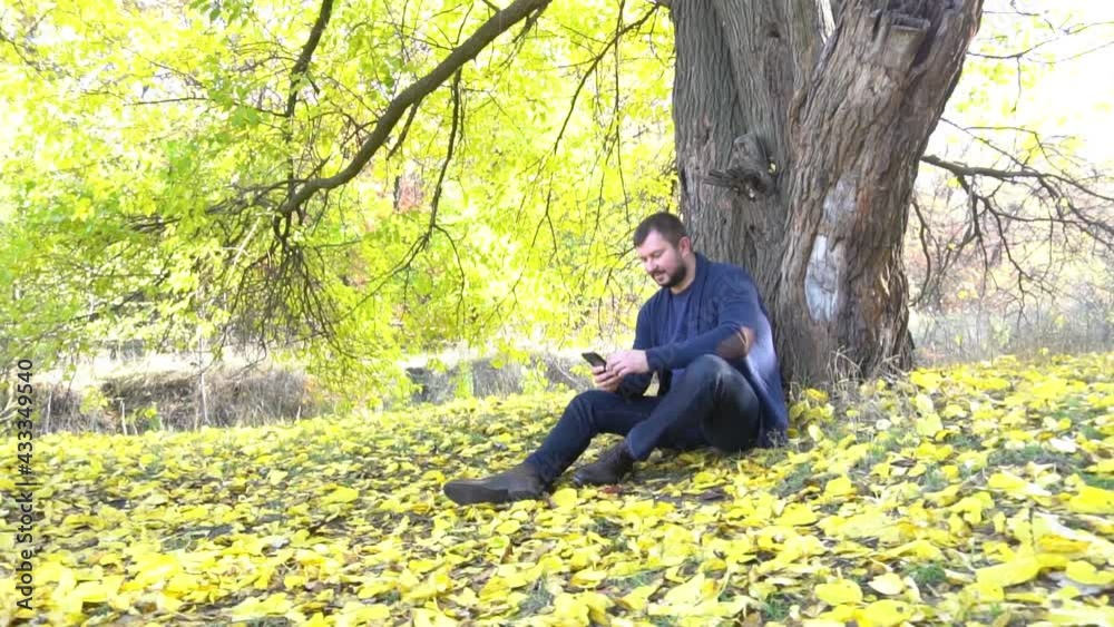 Slow Motion caucasian man in autumn holding a phone Slow Motion caucasian man in autumn holding a phone