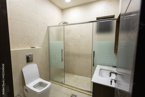 bathroom in gray and brown tones with heated floors  freestanding tub  walk-in shower.