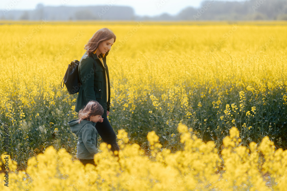 Mother and Daughter Walking in a Rapeseed Floral Field