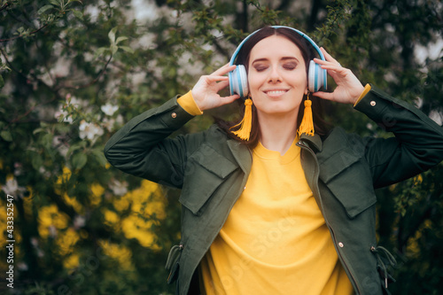 Happy Young Woman Wearing Headphones Outdoors in Nature