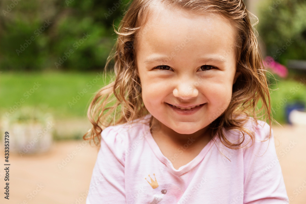 Close up portrait of smiling female toddler in garden Close up portrait of smiling female toddler in garden