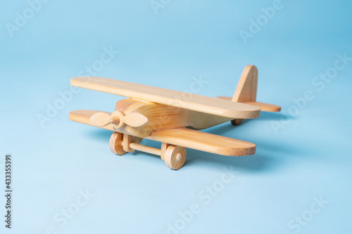 Wooden toy retro plane on a blue background.