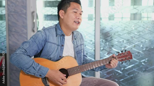 Male vlog influencer performance music show, teaching how to play guitar, streaming to internet online audience listening at home. Man sing a song with smile face. Home entertainer, blogger concept..