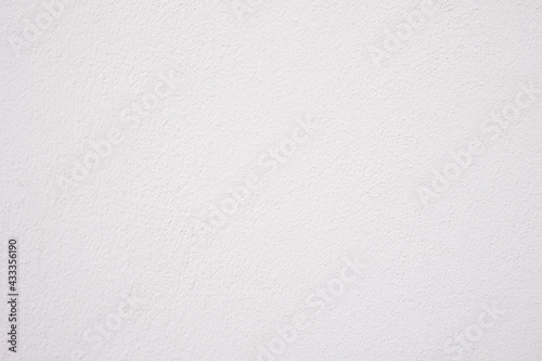 Close up and lay flat shot of concrete wall with white color painting shows texture and rough surface of material with bright and clean background. It is beautiful for blank background template.