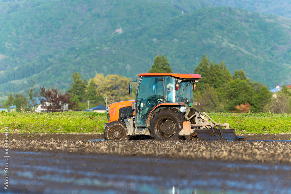 Fototapeta premium トラクターでの代掻き作業(田掻き) 農業 水田 稲 農家