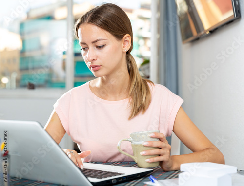 Attractive young woman working with her laptop at home