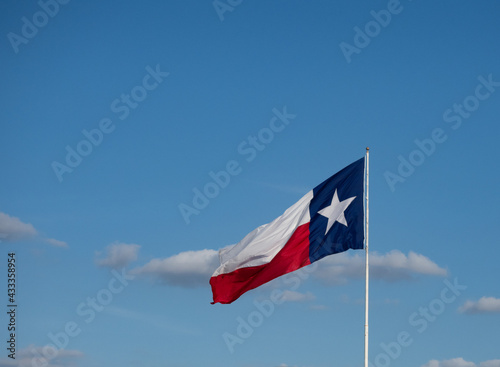 Horizontal Unfurled Texas Lone Star Flag with Clouds in Background