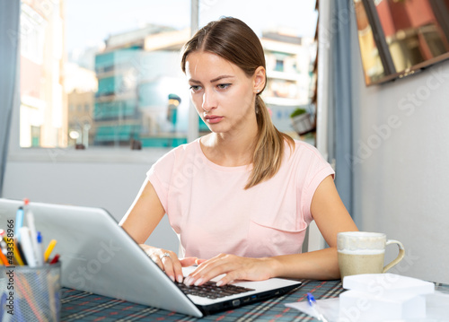 Cheerful girl relaxation at home and using her laptop