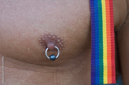 gay man chest with rainbow suspenders and  a pearcing on the nipple