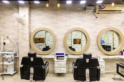 View inside of a modern salon showing mirrors and sitting arrangement. Beauty parlour interiors.