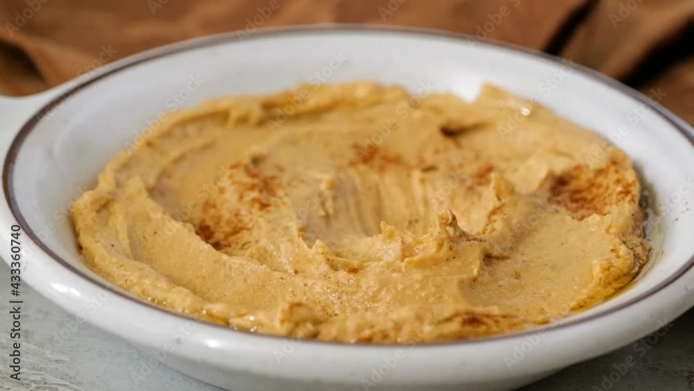 Dipping a broccoli floret in a dish of fresh hummus slow motion
Dipping a broccoli floret in a dish of fresh hummus slow motion