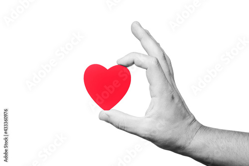 Black and white photo with red heart. Hand holding heart shape on a stick. Love symbol background. God have mercy on us. The hope for better.