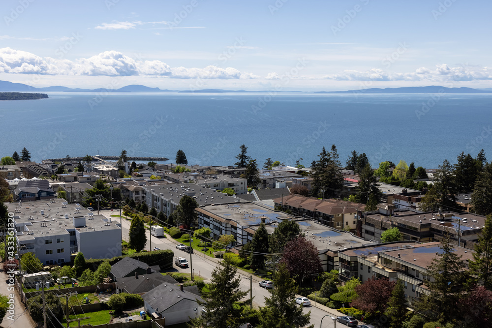 Aerial View of Residential Homes in a peaceful neighborhood by the Pacific West Coast Ocean. Sunny Spring Day. White Rock, Vancouver, British Columbia, Canada.