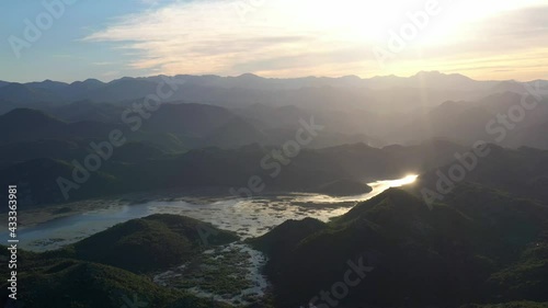 Panoramic view of green mountains in water of Skadar lake at sunset, Montenegro