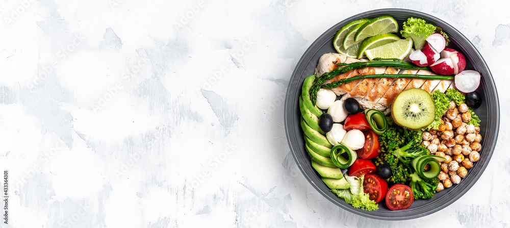 Buddha bowl dish with chicken fillet, asparagus, chickpeas, broccoli, radish, cucumber, avocado, tomatoes, mozzarella. Detox and healthy superfoods bowl concept, top view, flat lay