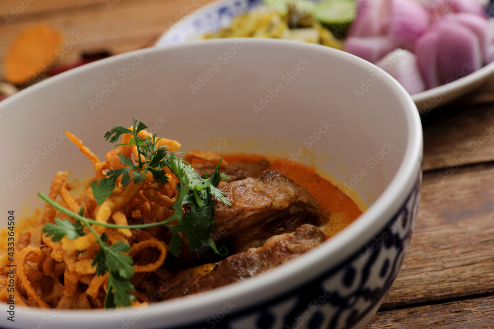 Local northern Thai food Egg noodle curry with pork ribs on wood background Local northern Thai food Egg noodle curry with pork ribs on wood background