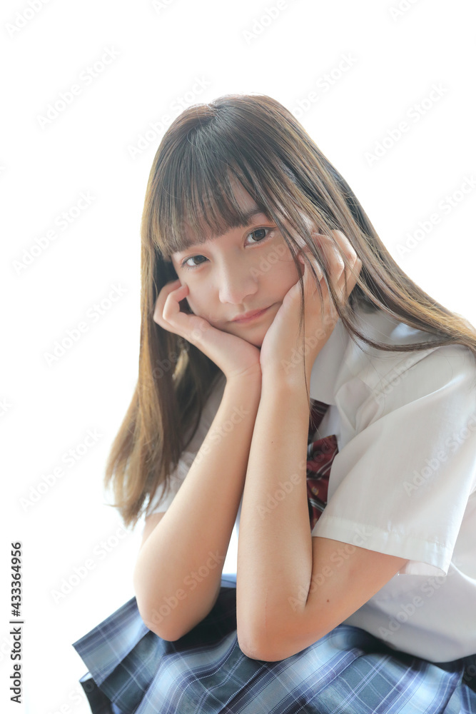 Portrait japanese school girl uniform sitting and look at camera in white tone bed room Portrait japanese school girl uniform sitting and look at camera in white tone bed room