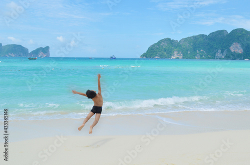 Little boy jumping in front of Koh Phi Phi Island beach in Thailand
