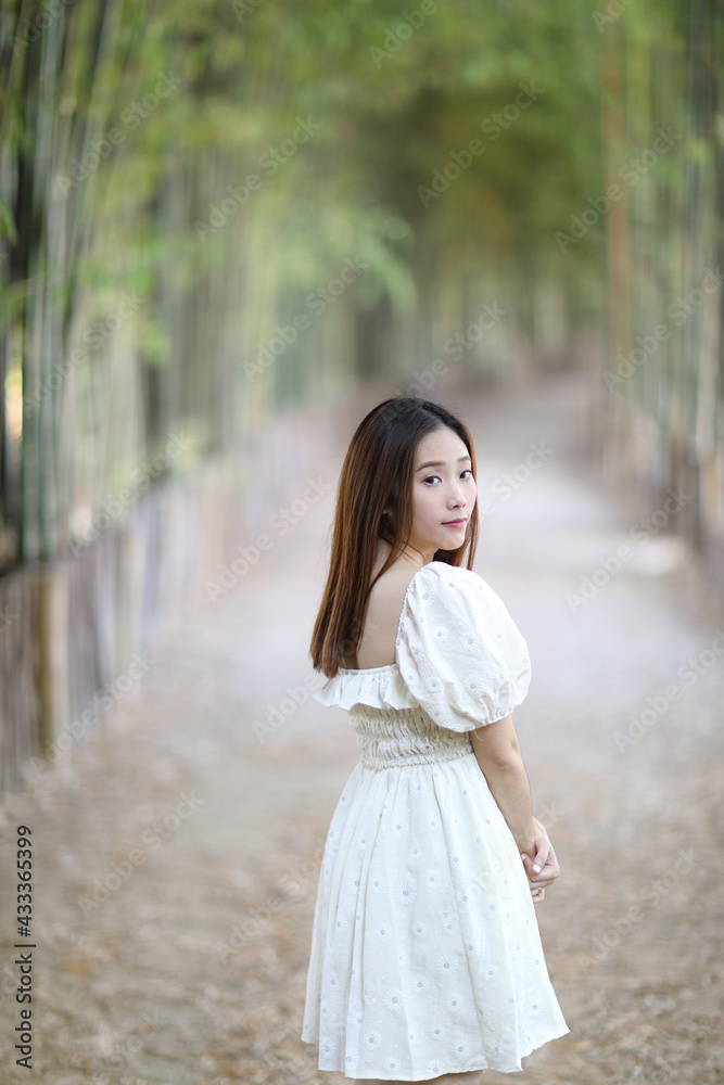 Beautiful young woman with white dress on bamboo forest background Beautiful young woman with white dress on bamboo forest background