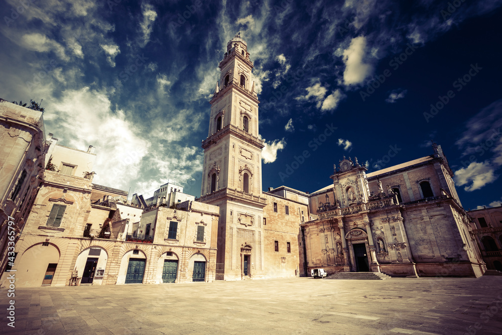 Square of the famous basilica Church of the Holy Cross. Historic city of Lecce, Italy. Blue sky with some clouds