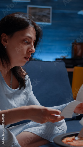 Confused frustrated nevous young woman reading letter, debt notification, bad financial report, money problem, eviction notice. Shocked, worried tenant by warning document for unpaid bank bills photo