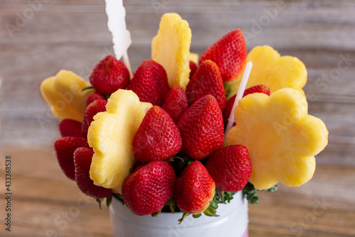фотографія A view of a bouquet of fruit, featuring pineapple flowers and strawberries