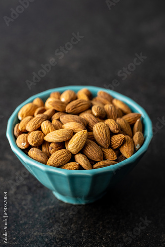 Almond nuts in bowl on black table. © Jiri Hera