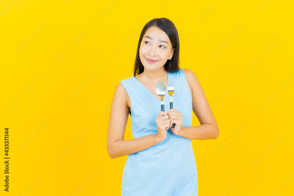 Portrait beautiful young asian woman smile with spoon and fork Portrait beautiful young asian woman smile with spoon and fork