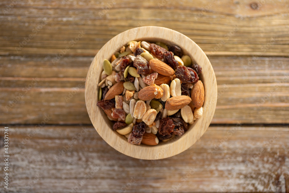 A top down view of a wood bowl of trail mix. A top down view of a wood bowl of trail mix.