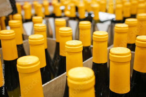 A view of a background of yellow wrapped wine bottles on display at a local retail store.