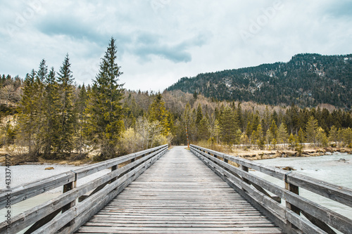 Einsame Holzbrücke in den Alpen über einen Fluss