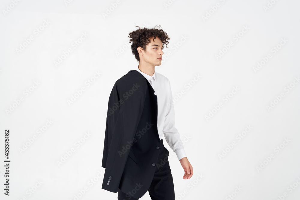 curly guy in a jacket shirt and trousers on a light background cropped view of the model curly guy in a jacket shirt and trousers on a light background cropped view of the model