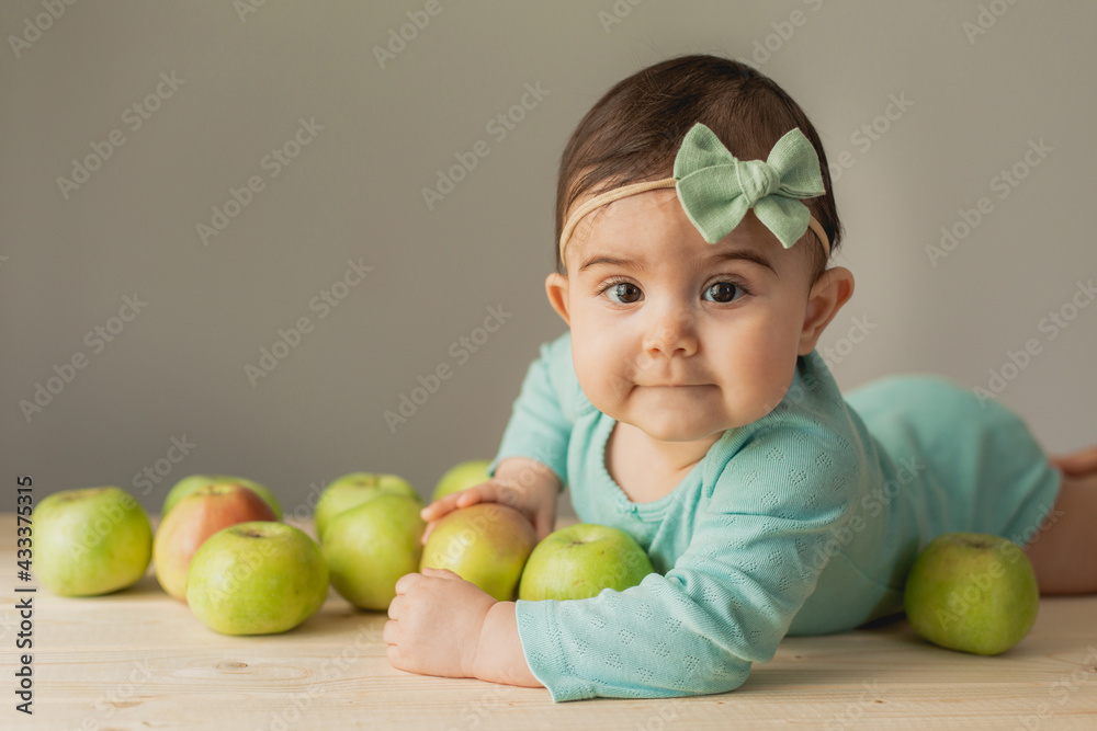 Cute little girl lies with green apples. eco-friendly products for children. High quality photo Cute little girl lies with green apples. eco-friendly products for children. High quality photo